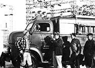 Employees standing by old truck