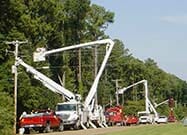 bucket trucks next to transmission line
