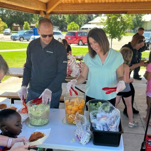 Employees volunteer during lunch break to serve meals to kids